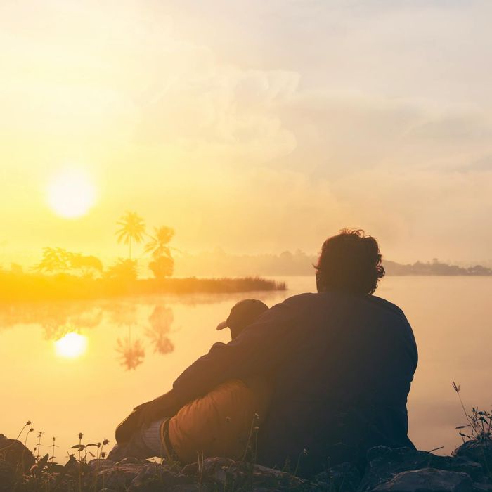Person stretching gently outdoors during a beautiful sunrise.